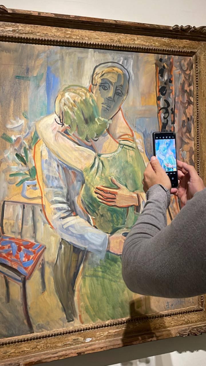 Pessoa fotografando quadro expressionista em museu com celular